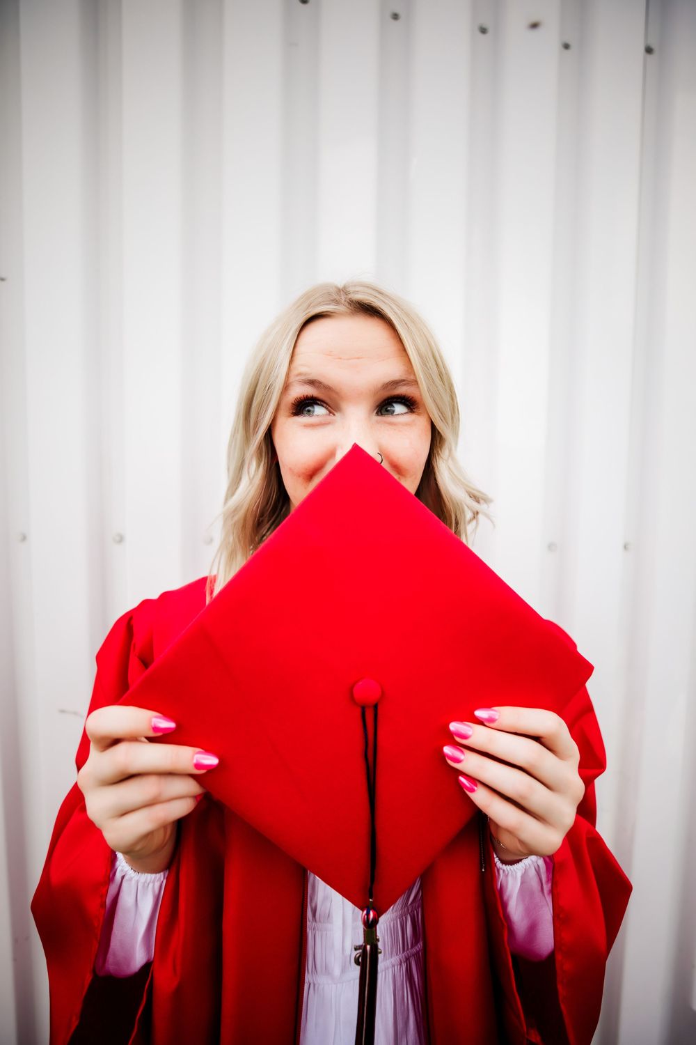 Senior girl poses with her red cap and gown in Dickson, TN