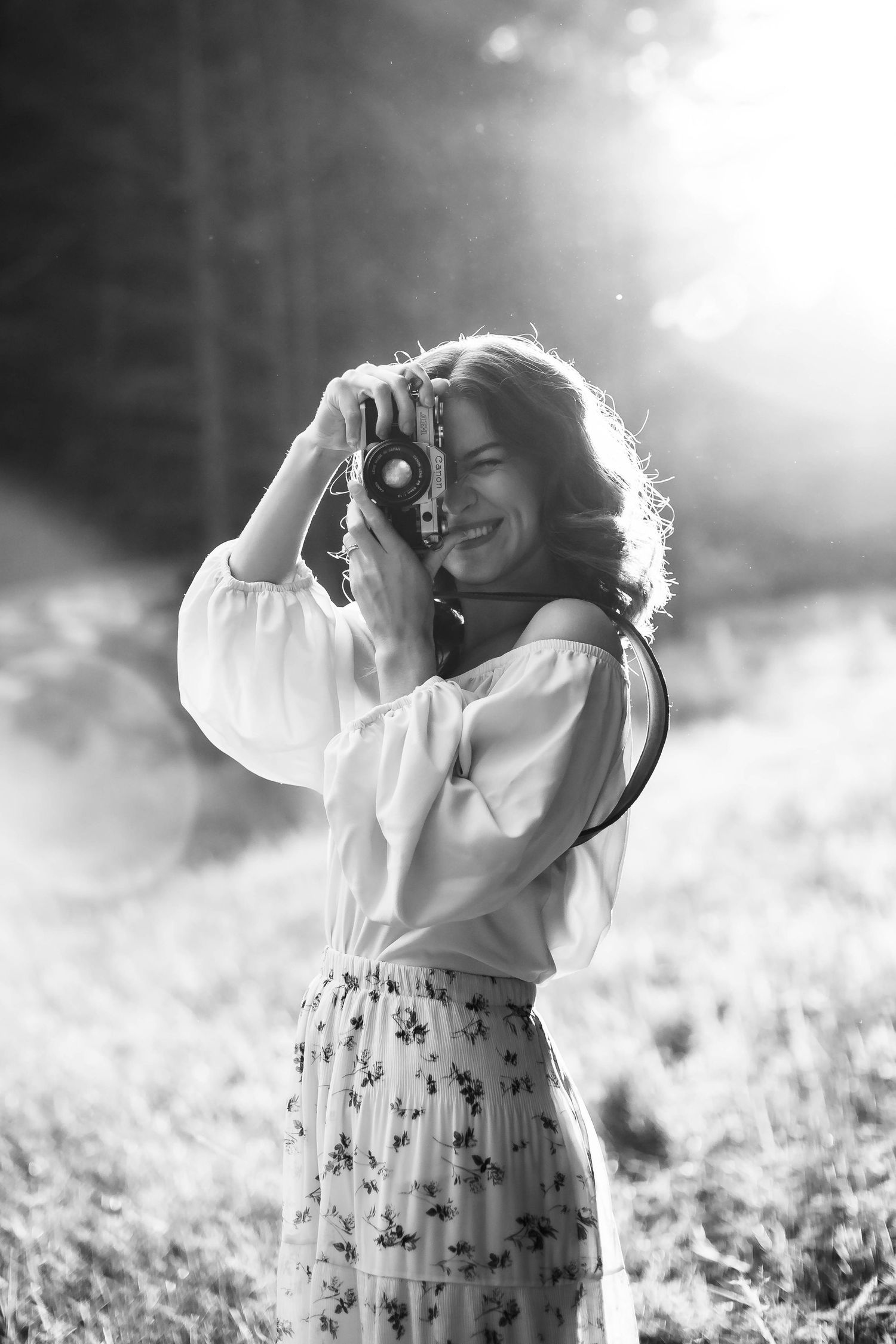 Naomi smiling while holding film camera