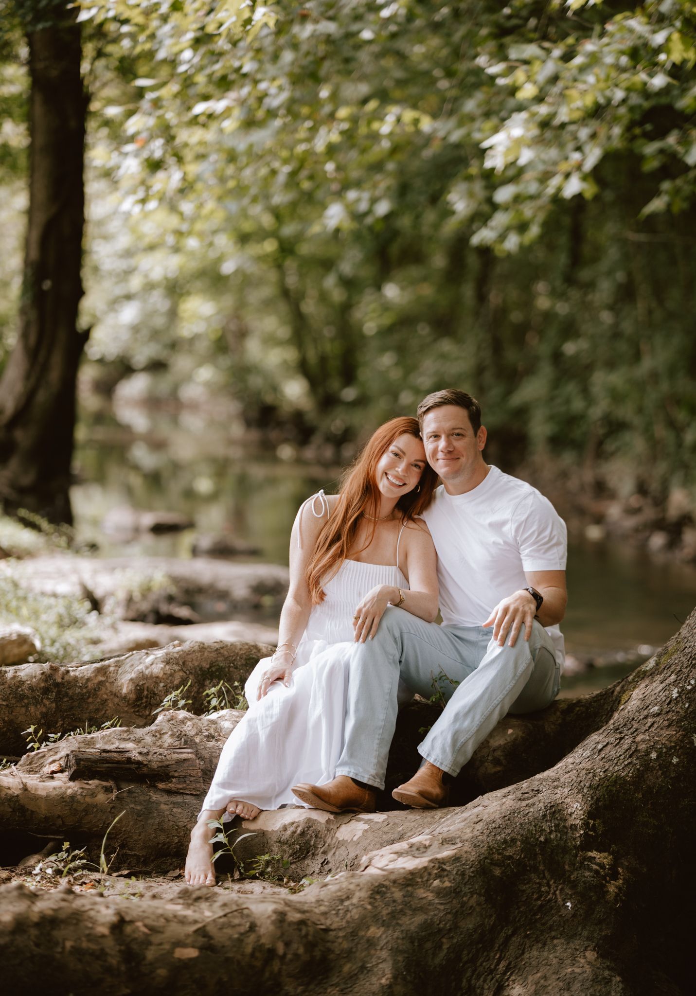 A romantic couple embraces in front of a rustic fence during sunset in a fall field.