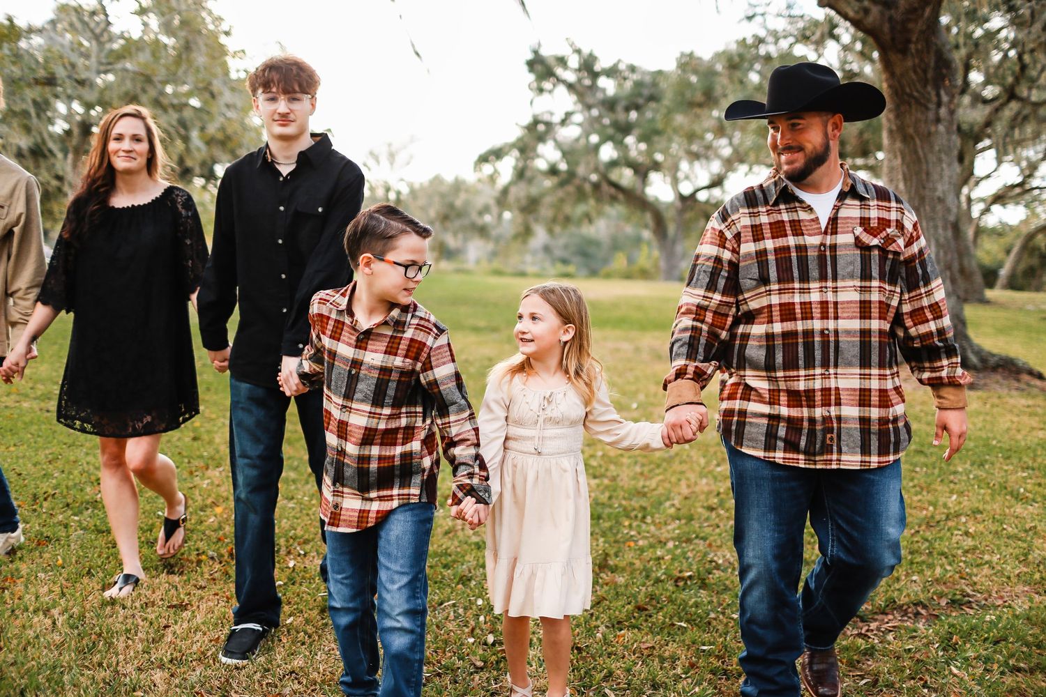 Family holding hands for family session while walking at church
