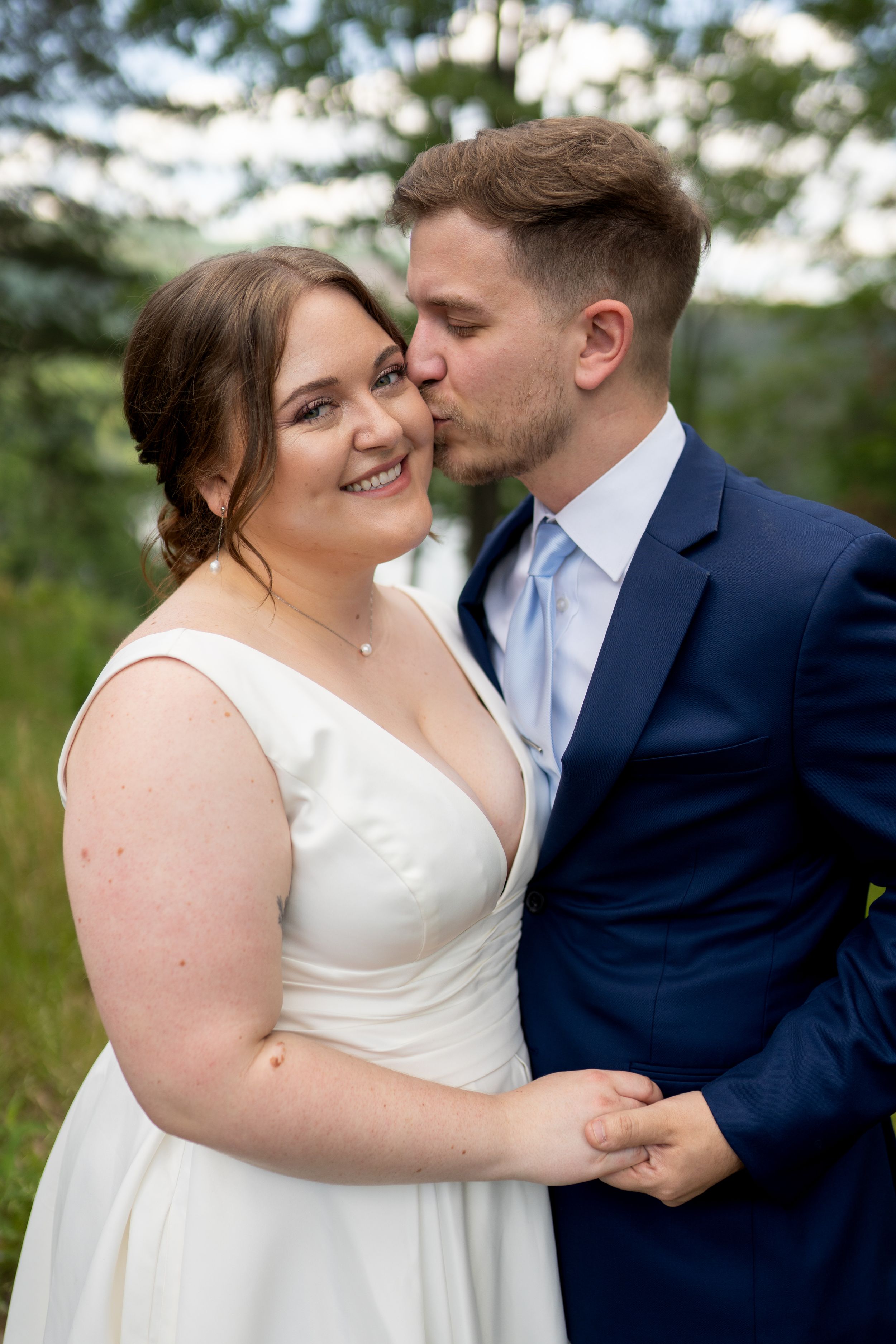 Intimate wedding portraits of a couple laughing and embracing in outdoor natural light.