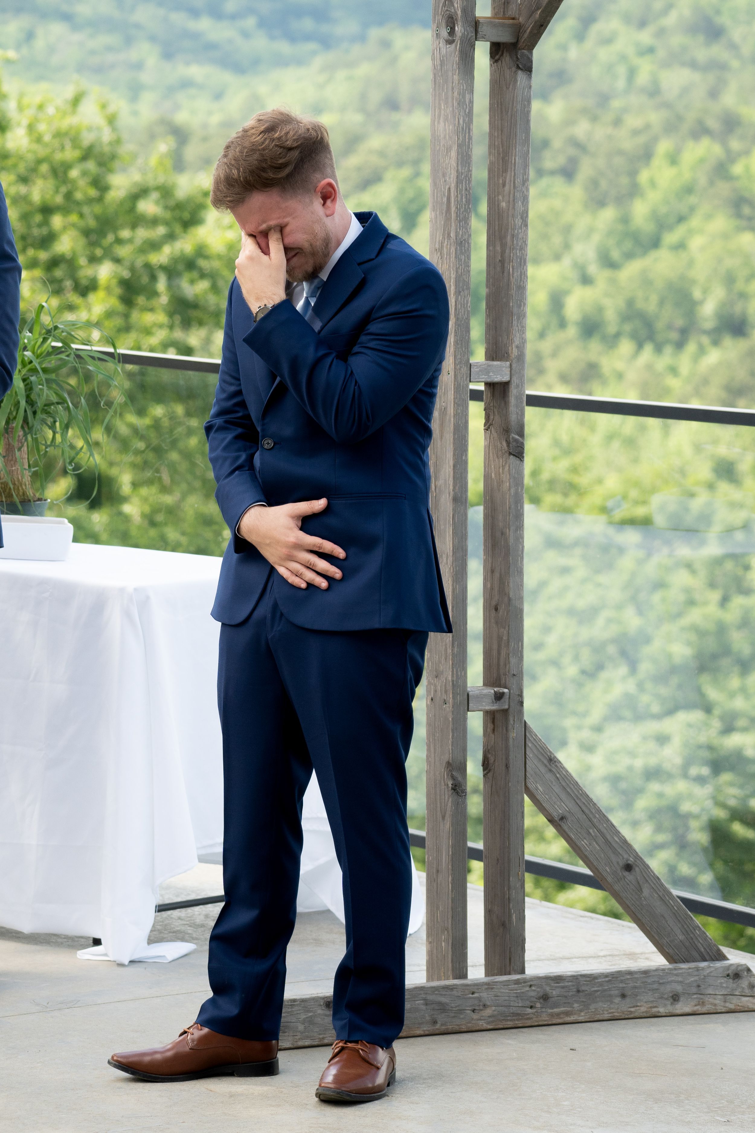 Emotional moments captured on wooden deck overlooking mountain landscape.