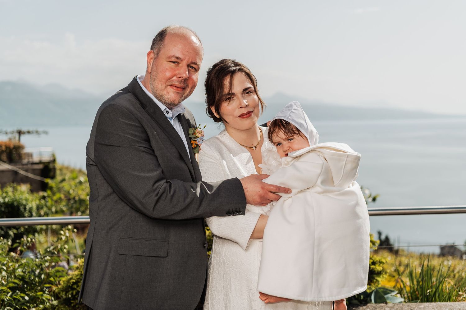 Wedding couple shares tender moments on a scenic terrace overlooking the water.