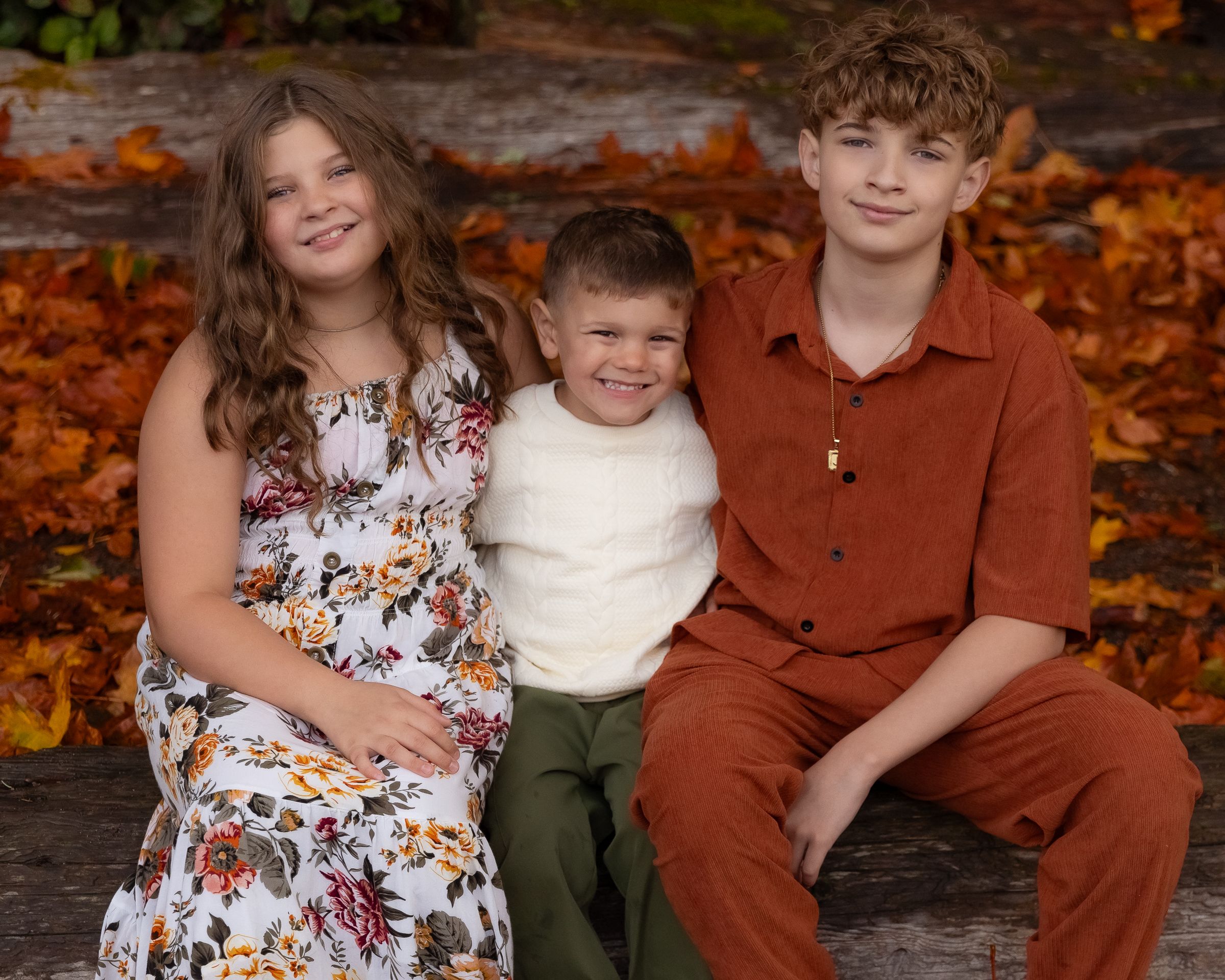 Siblings pose for fall family photos in Tacoma during a fall family session.