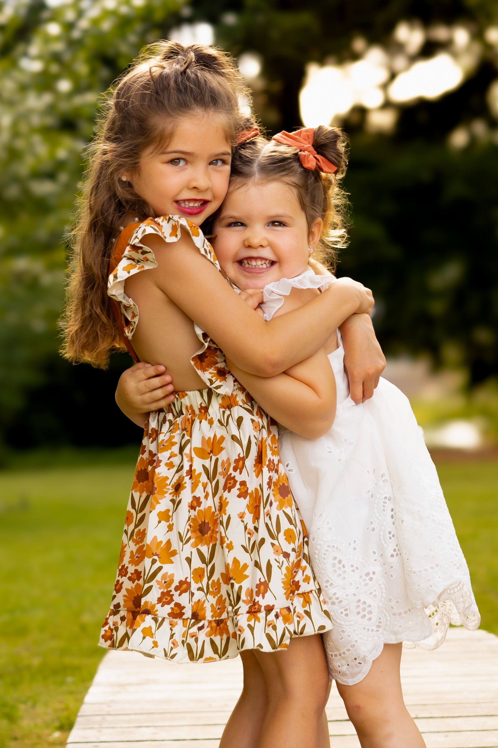 Sisters hug, smiling for a photograph by Washington photographer Jess Bickel.