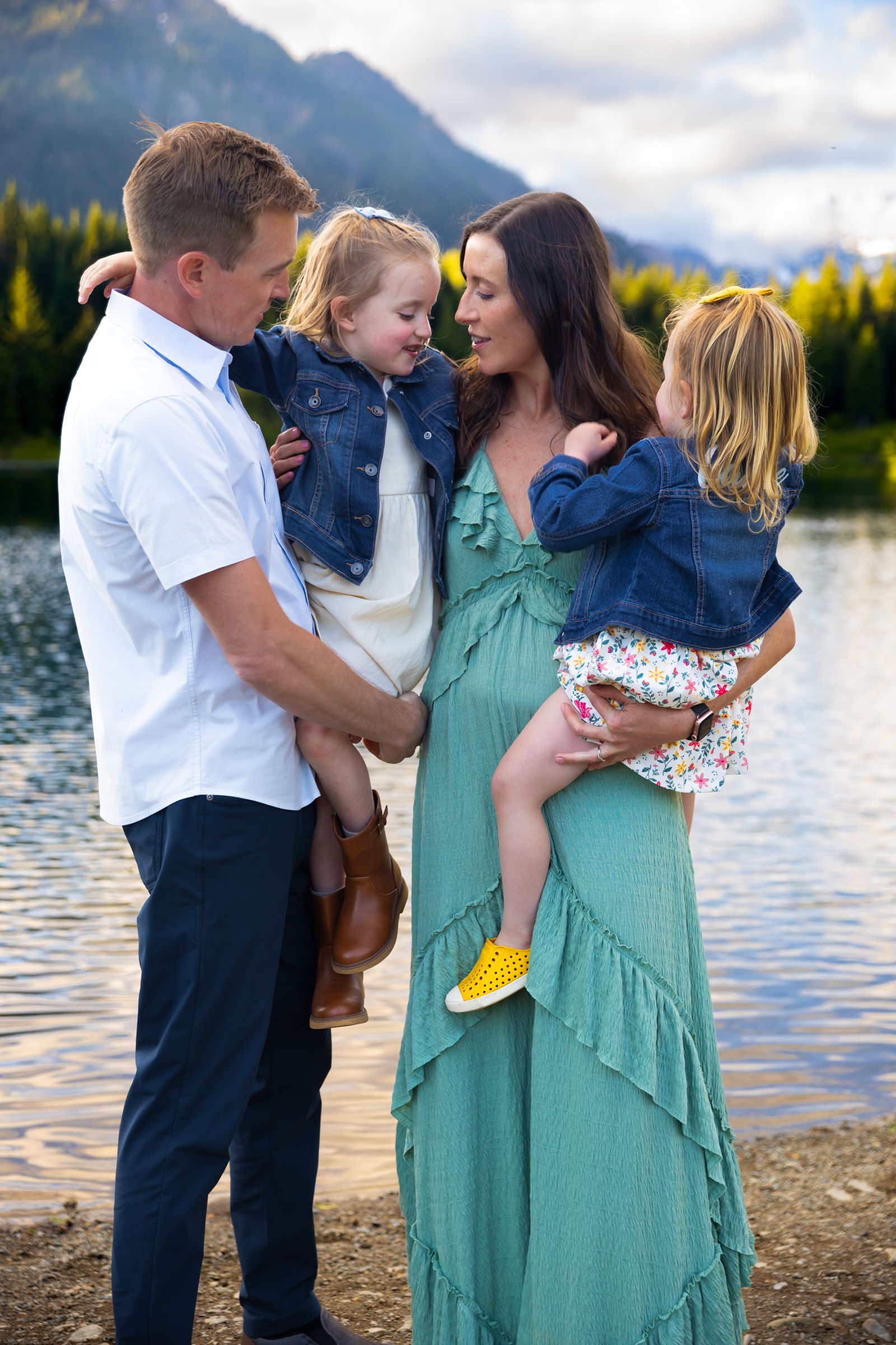 A family pose for a photograph in front of a lake and mountainous landscape in Washington State.