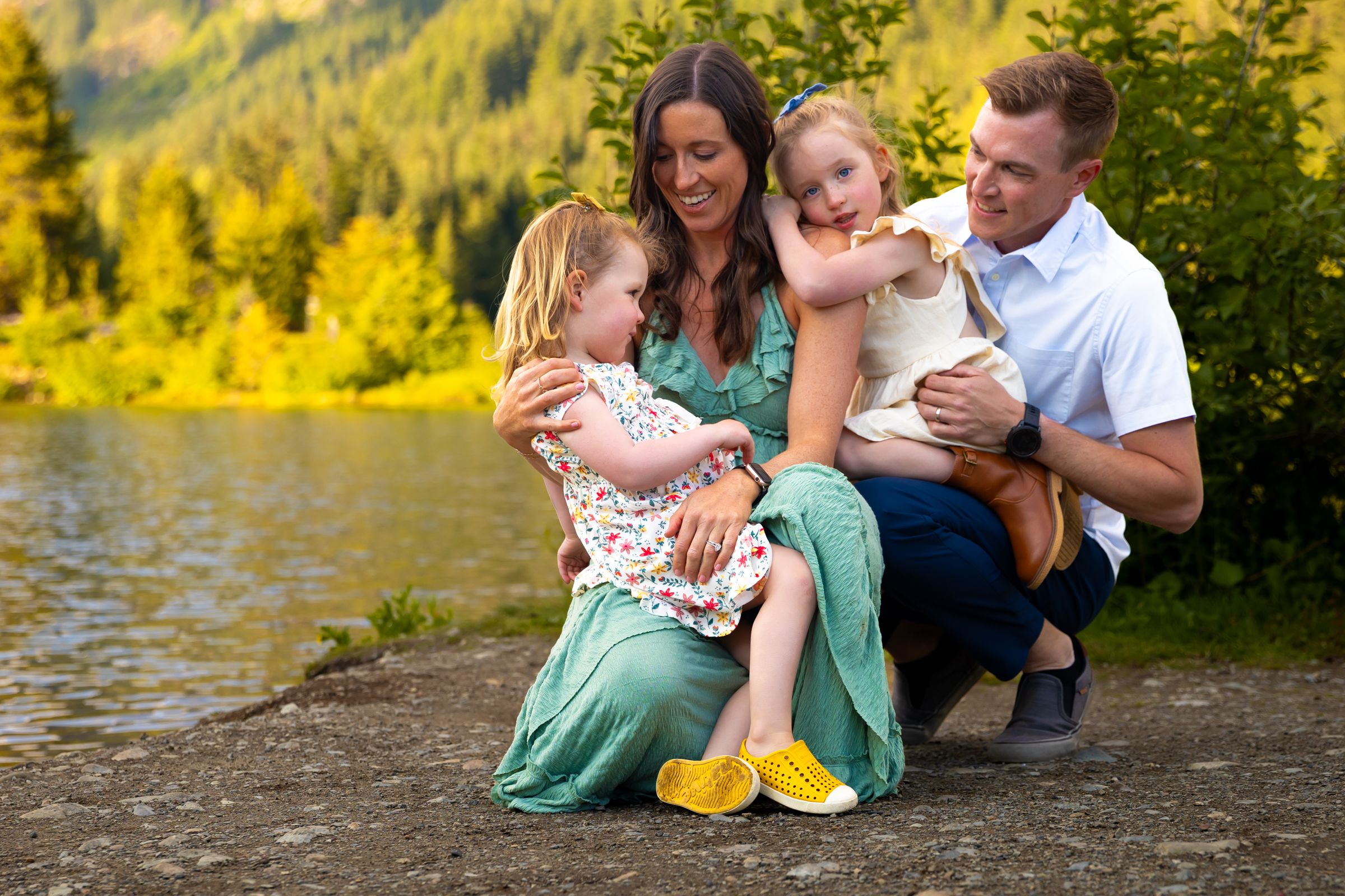 A family interact lovingly at the edge of a lake in Snoqualmie, Washington.
