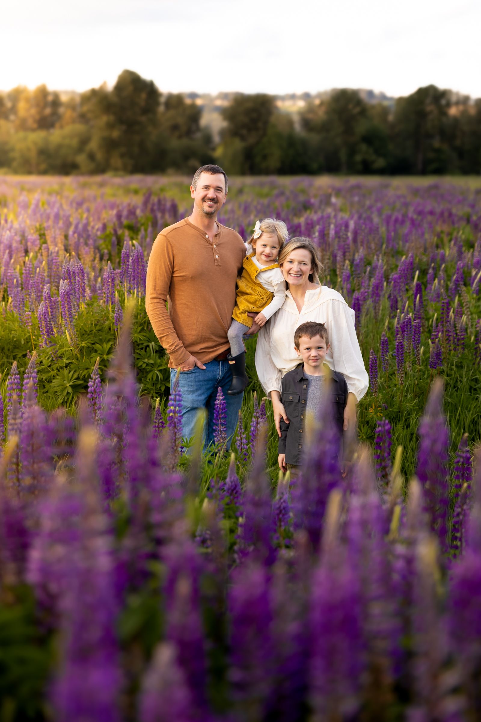 A Washington family pose in a field of dense lupine near Sumner, Washington.