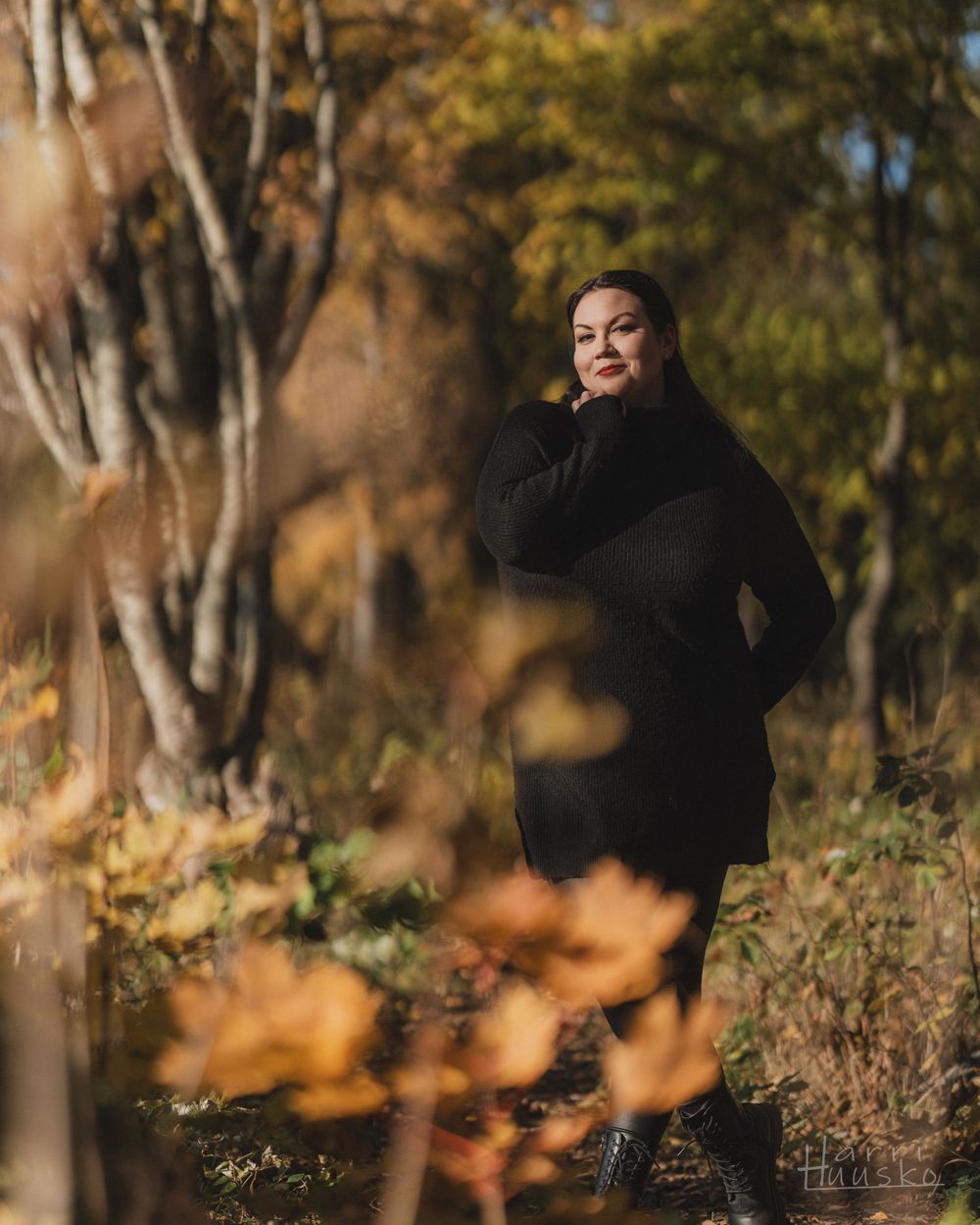 Autumn portrait in black coat against golden foliage and birch trees.