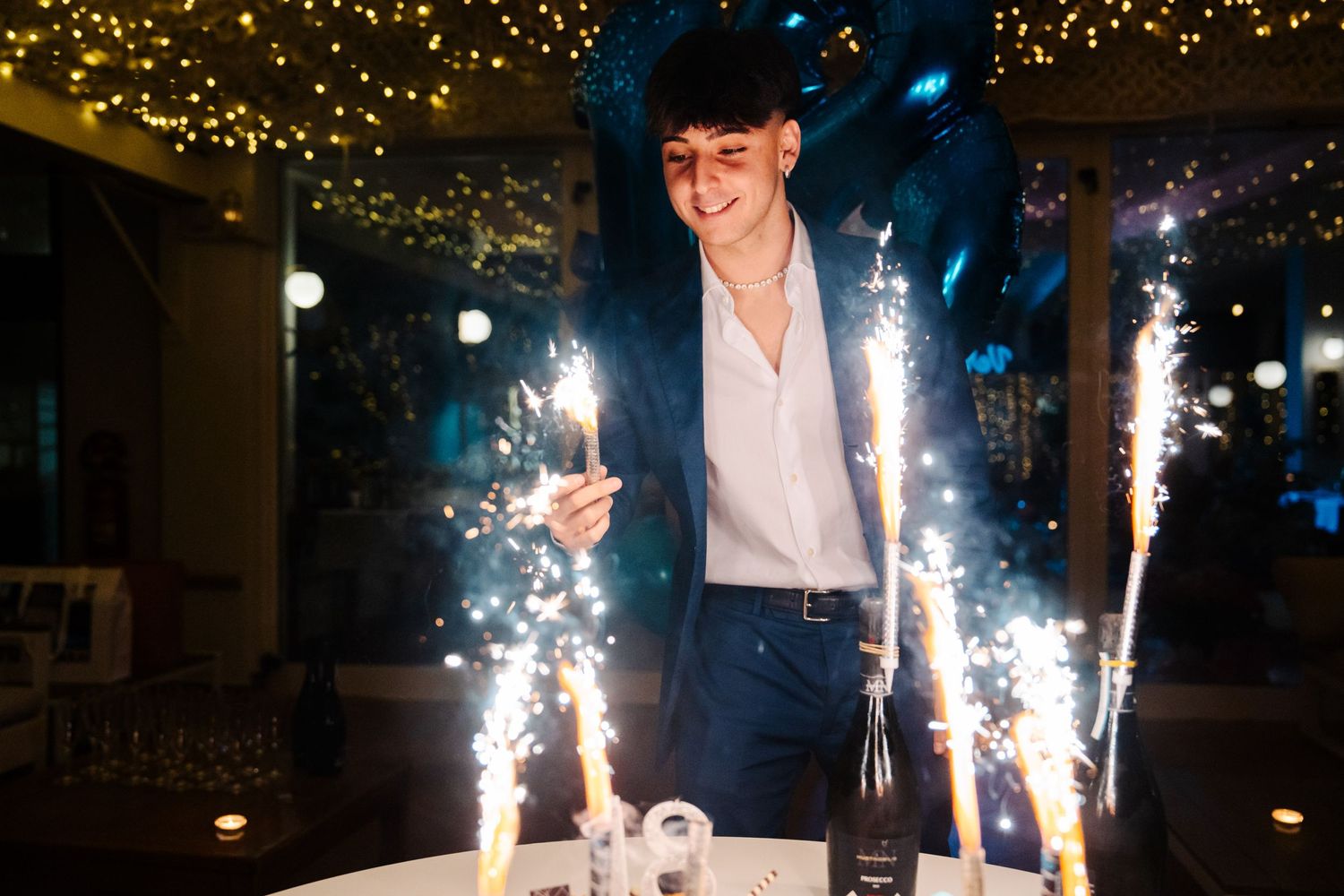 Ragazzo giovane che festeggia il suo diciottesimo compleanno alla Terrazza Versilia a Pietrasanta in Toscana con la torta e le candeline