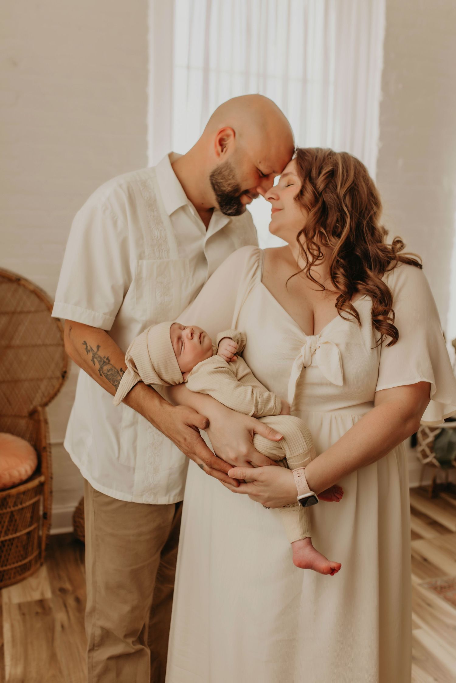 Tender family moment with newborn baby in warm, natural light setting.