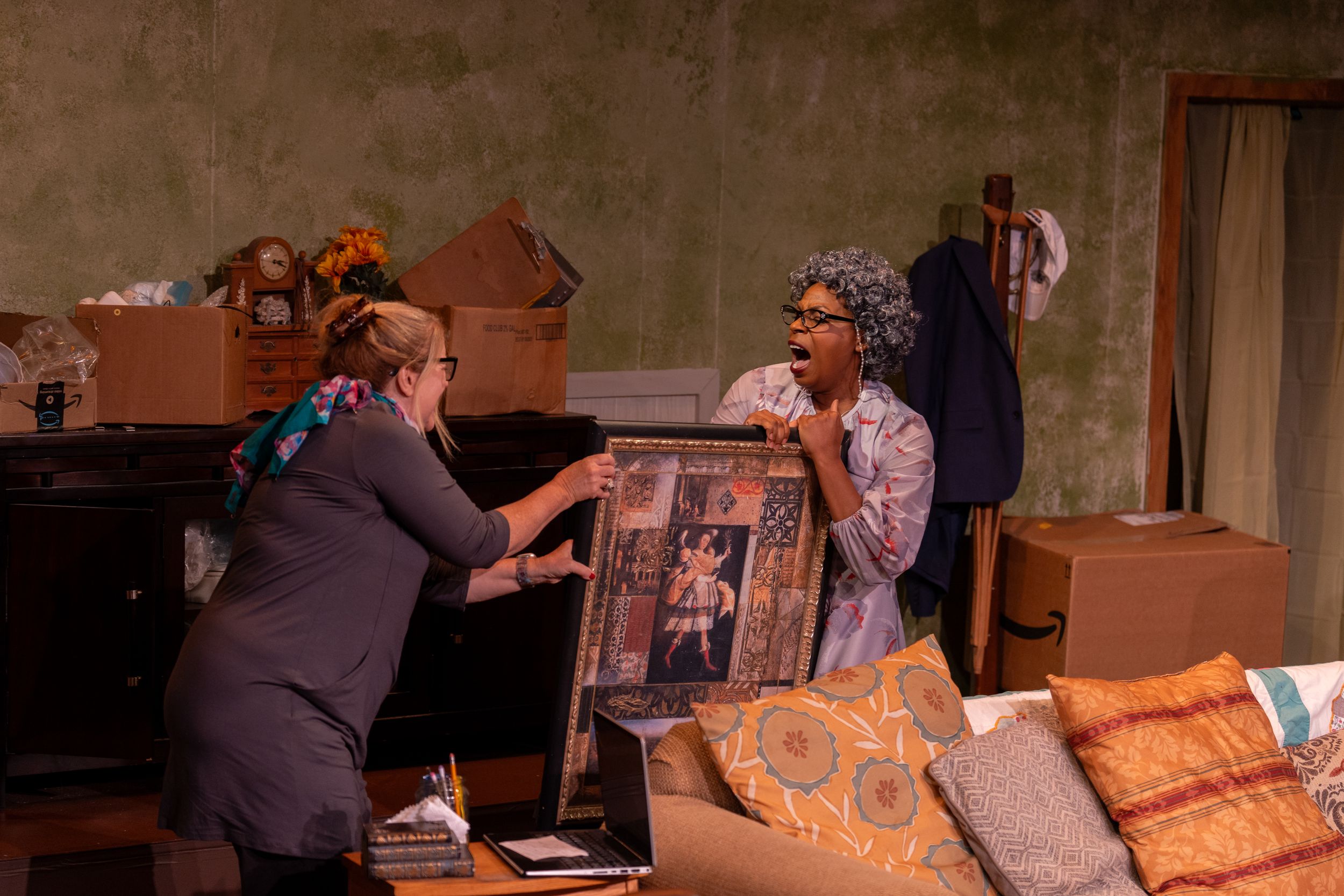 Two performers interact with a framed picture during an emotional scene.