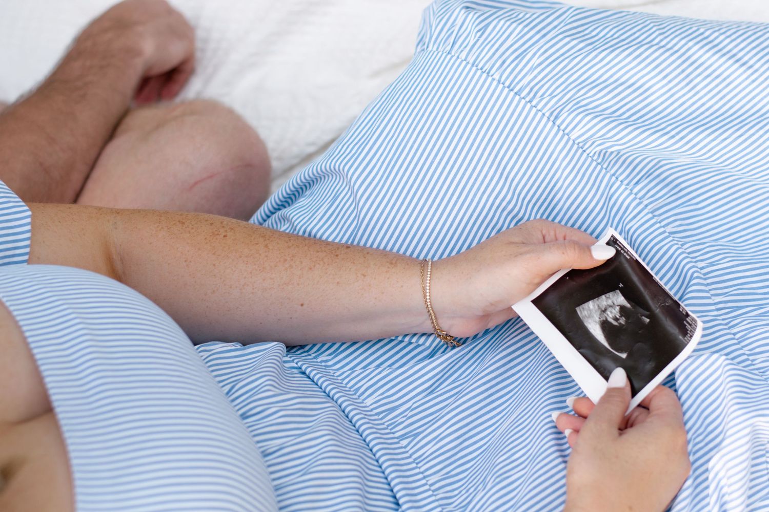 Maternity Photos, mom holding her ultrasound photo looking at it with dad
