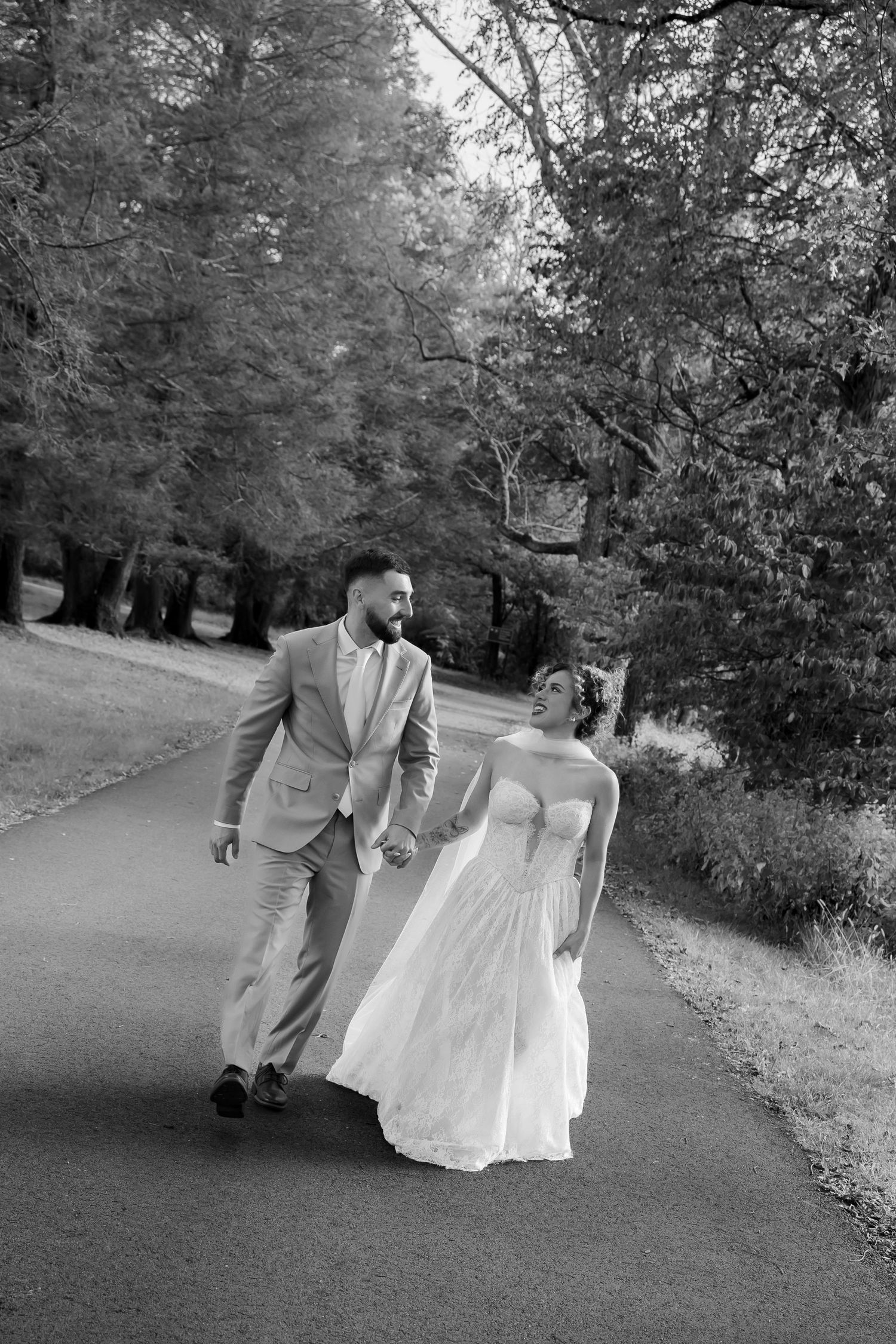 Black and white photos of a couple walking along a tree-lined path.