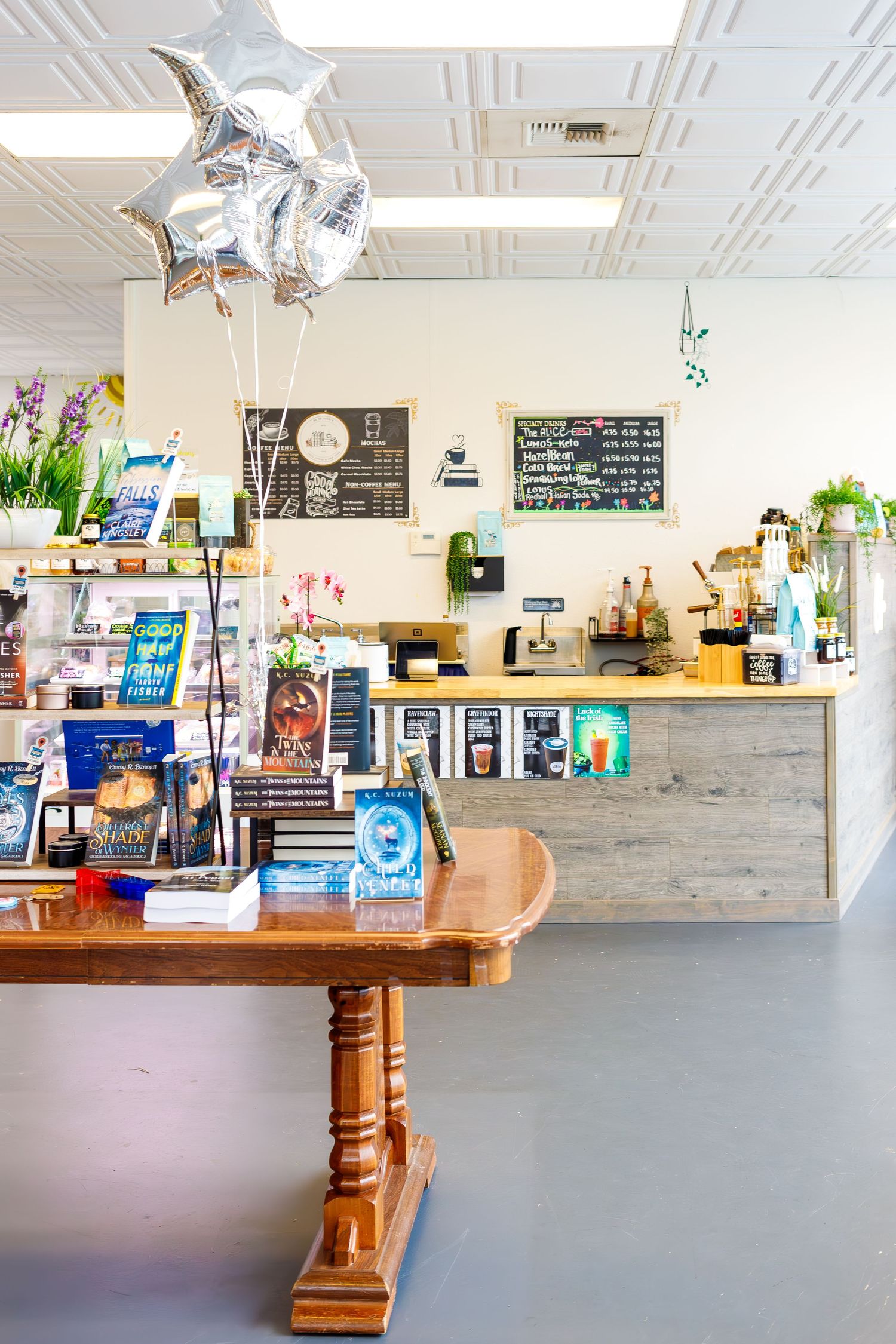 Charming retail shop interior with silver star balloons, wooden table displays and white ceiling details.