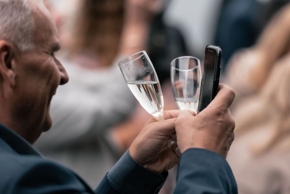 Someone holding two champagne glasses at a celebration or social gathering.