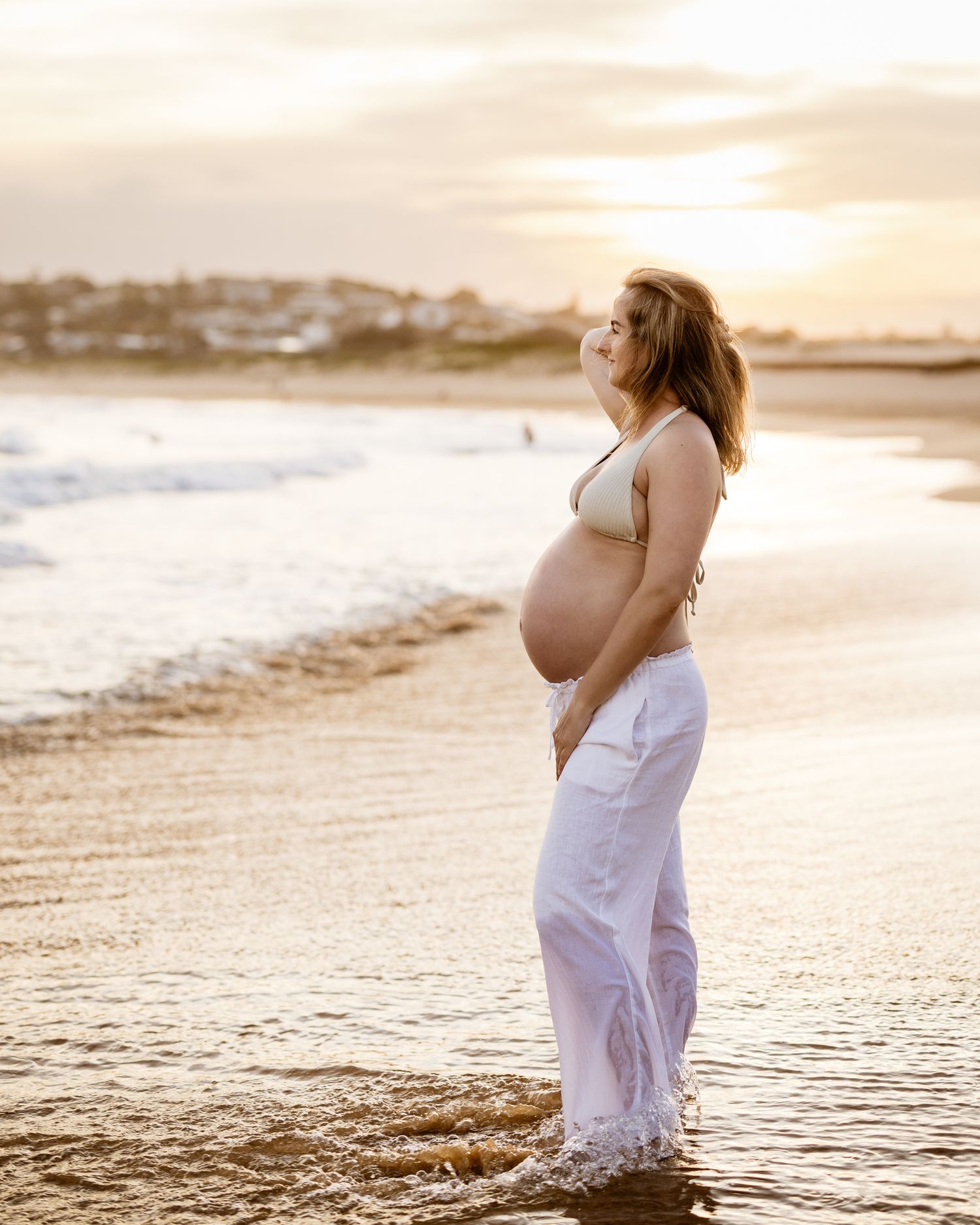 mum-to-be resting hands on bump during a golden hour shoot in St Ives