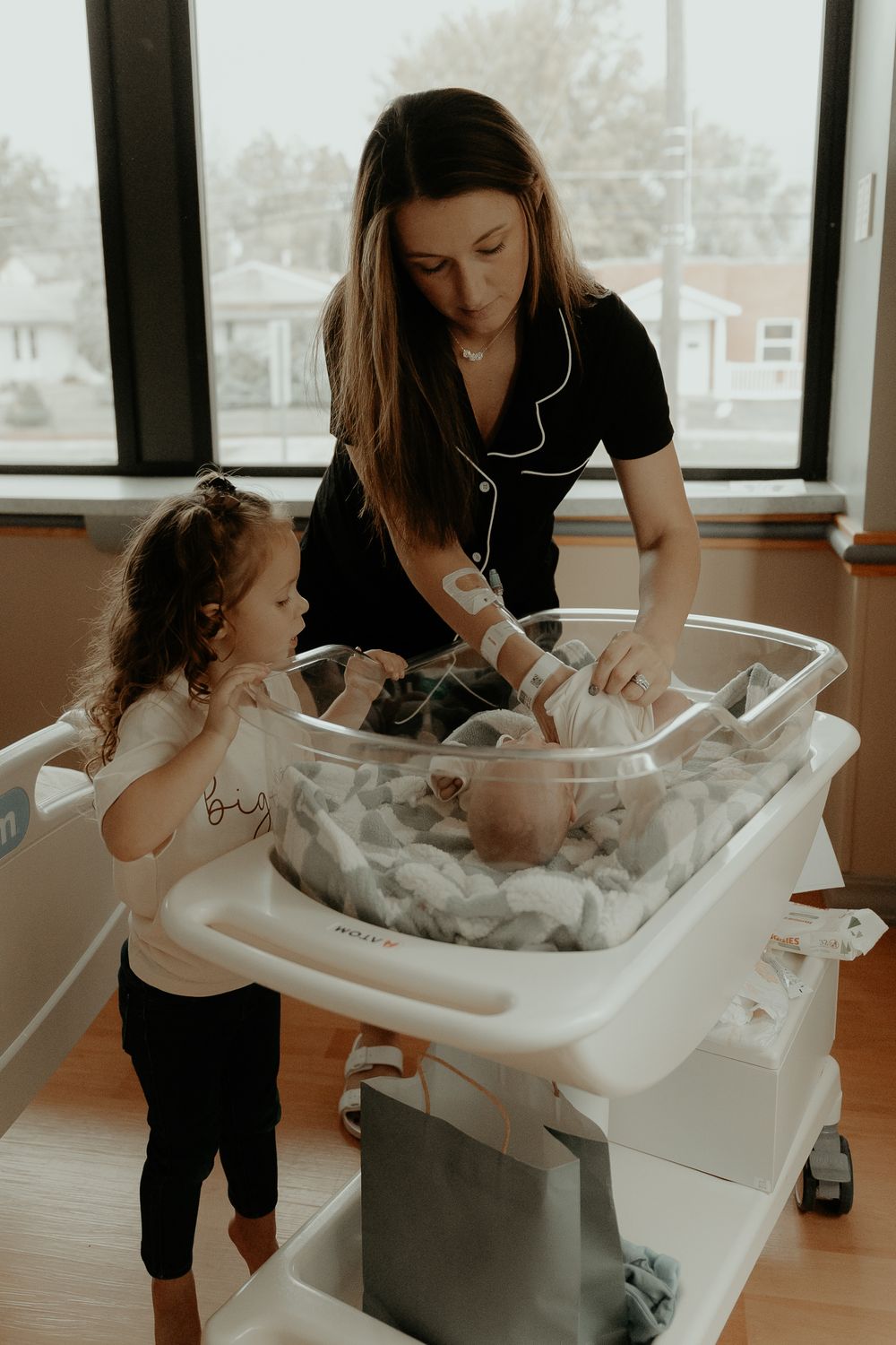 A newborn baby gets their first bath in a hospital bassinet.