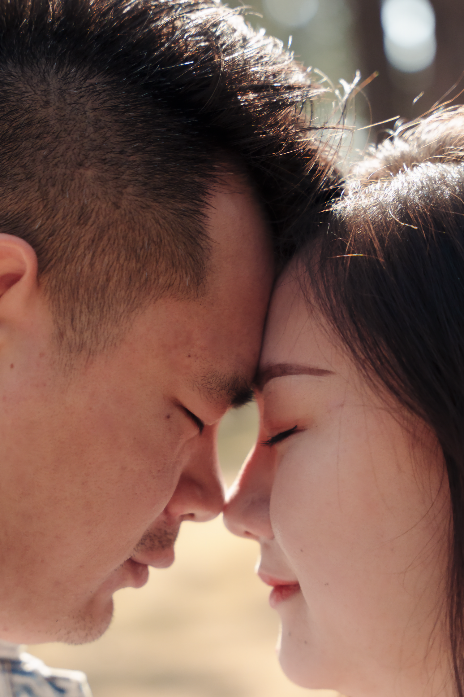 An intimate close-up of a couple sharing a tender moment with their faces nearly touching.
