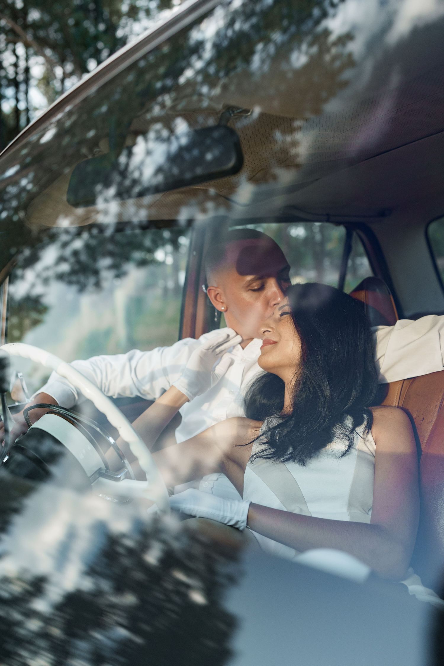 Romantic moment captured through car windshield as couple shares intimate moment.