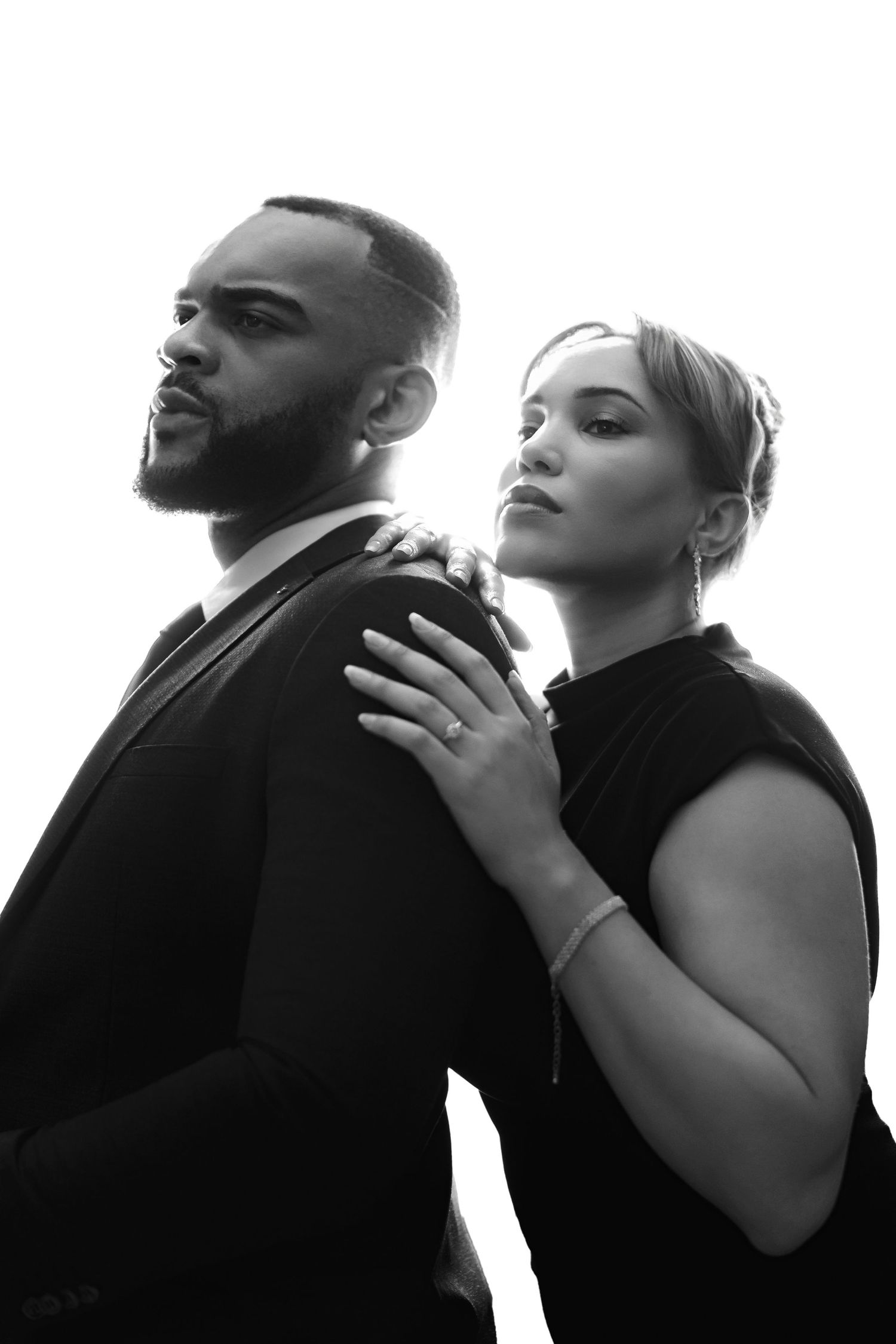 Black and white dramatic portrait series shows intimate poses of two people in contrasting lighting.