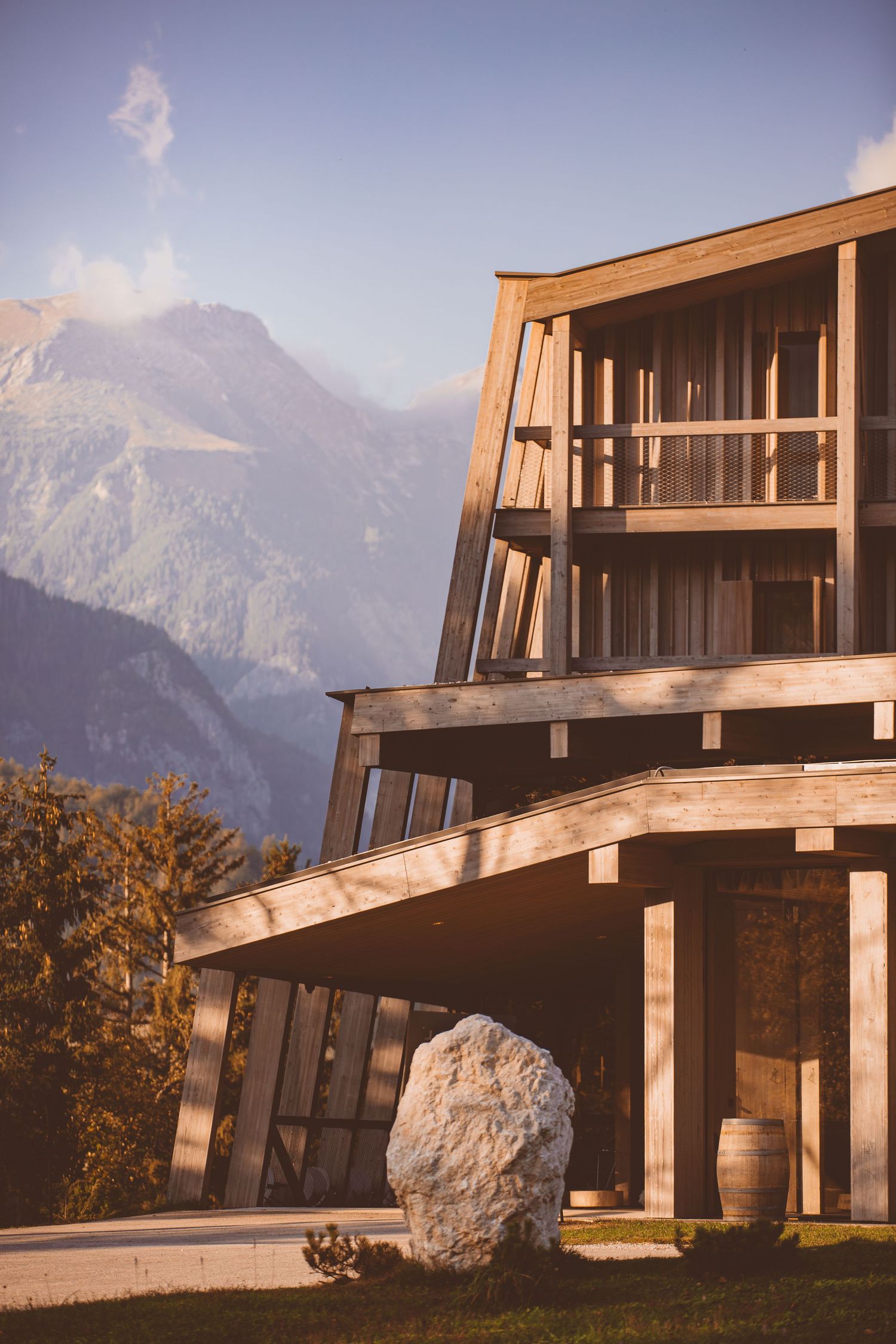Modern mountain lodge with dramatic architectural angles set against majestic alpine backdrop.
