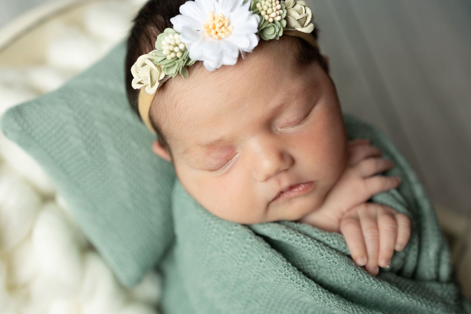 Adorable baby portraits on soft gray fur backdrop in pink outfit.