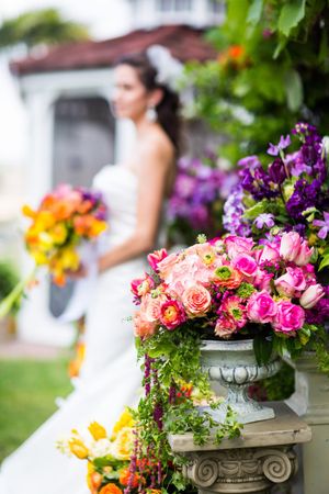 Colorful floral arrangements with roses and vibrant flowers in an ornate garden setting.