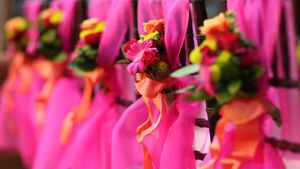 Row of pink bouquets with orange accents tied with ribbons.