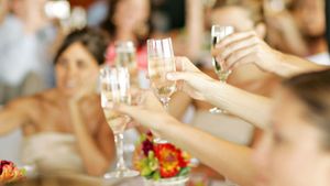 Guests raising champagne glasses in a wedding toast celebration.