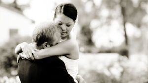 A tender black and white embrace captured during a wedding celebration.