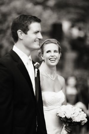 Classic black and white portrait of newlyweds smiling together outdoors.