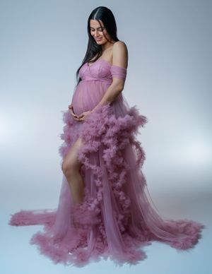 Lavender tulle maternity gown with ruffled details and high slit.