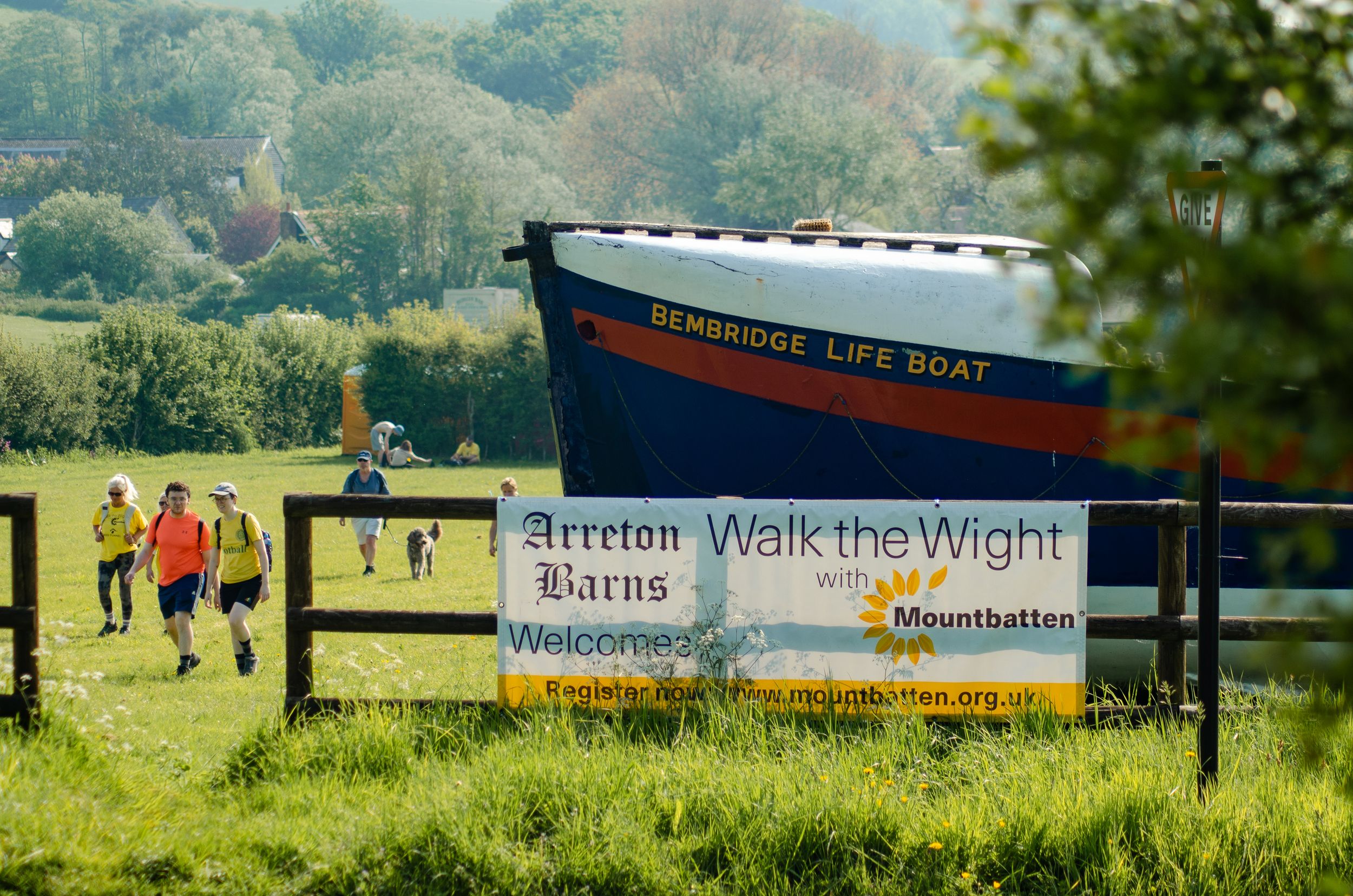 Sign for Walk the Wight community event with people walking in background.