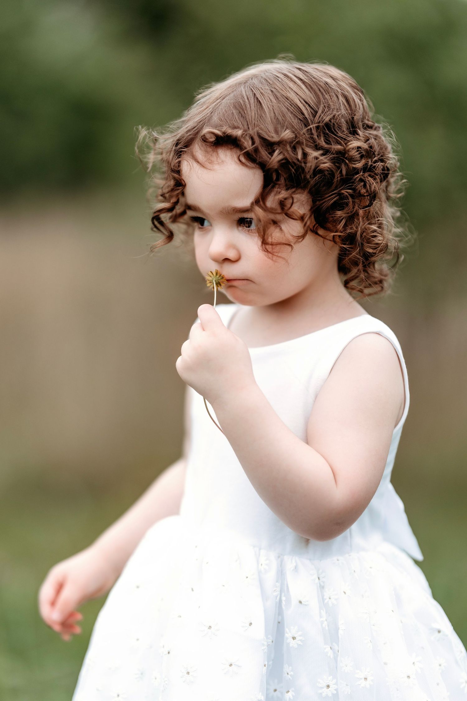 two year old outside smelling a flower Middle TN milestone photographer.