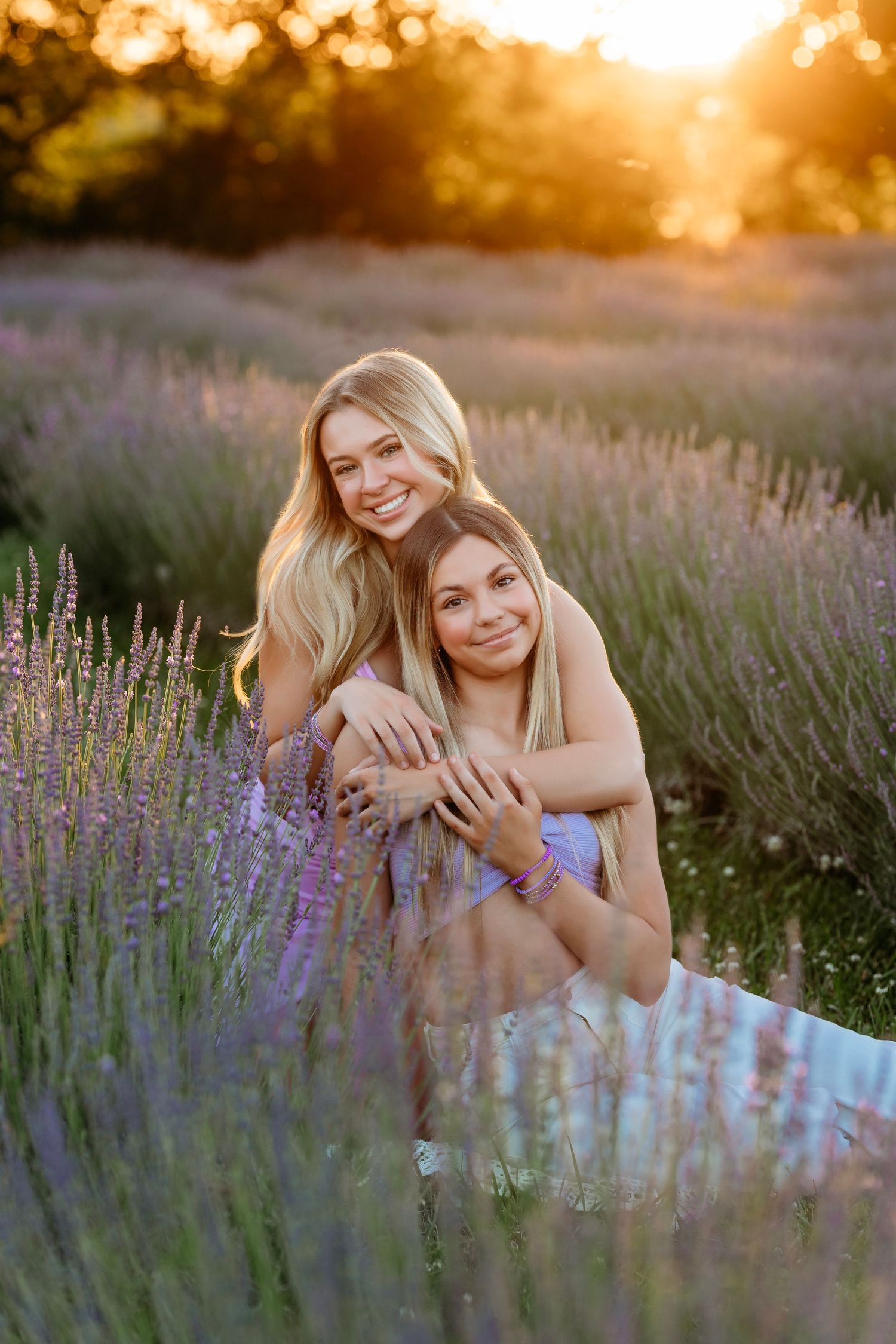Dreamy sunset photoshoot in a blooming lavender field with warm golden light filtering through the purple flowers.  Siblings