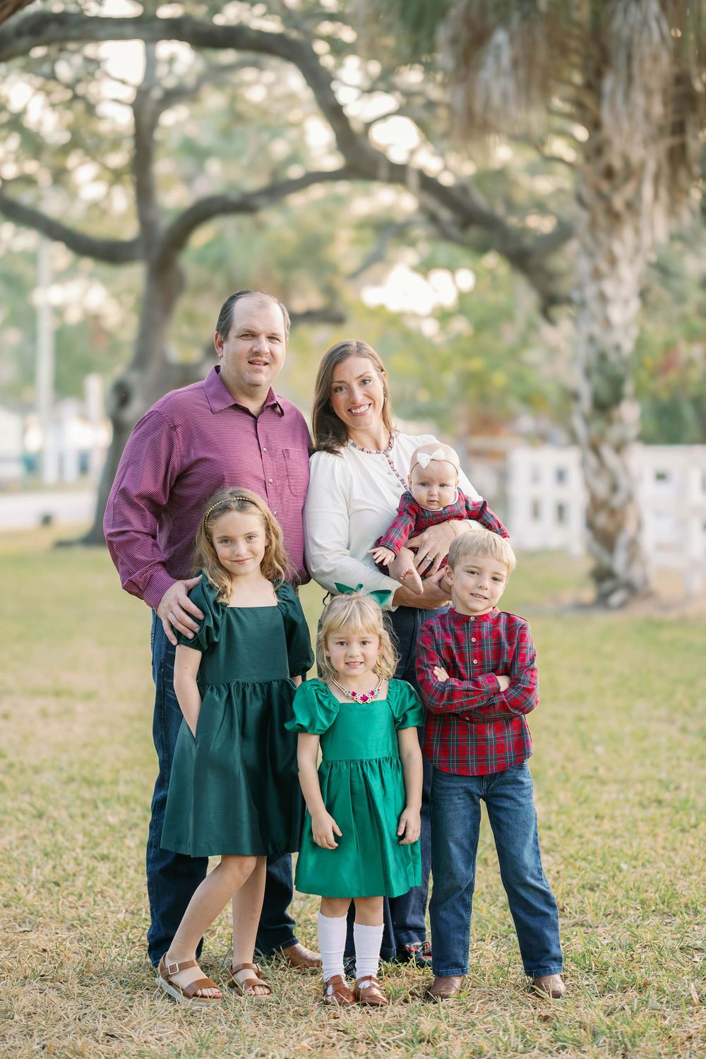 Family sitting together on blanket during outdoor photo session.