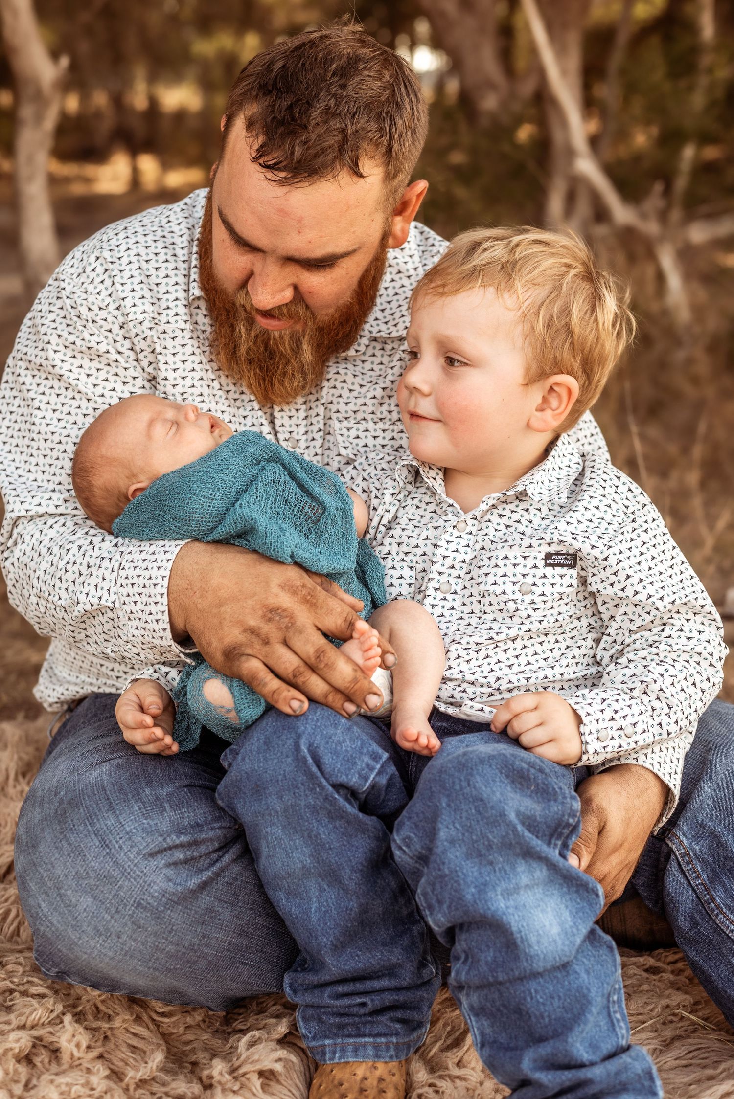 Family bonding moment outdoors with coordinating outfits and gentle expressions.