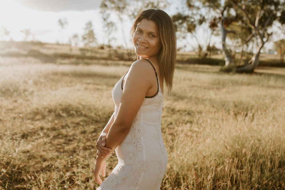 mother poses for the camera as the sunsets in Mount Isa