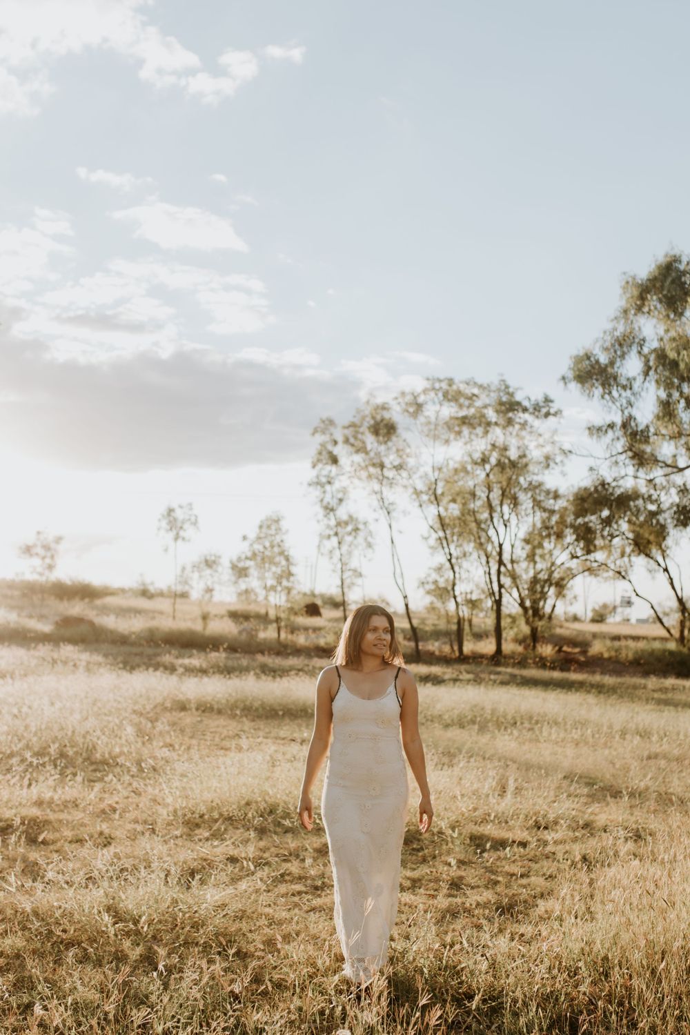 woman walks through the field as the sunsets in Mount Isa