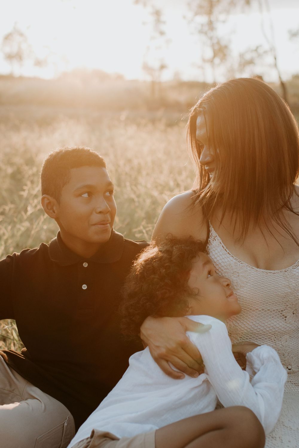 close up of mother and sons smiling as the sunsets in Mount Isa