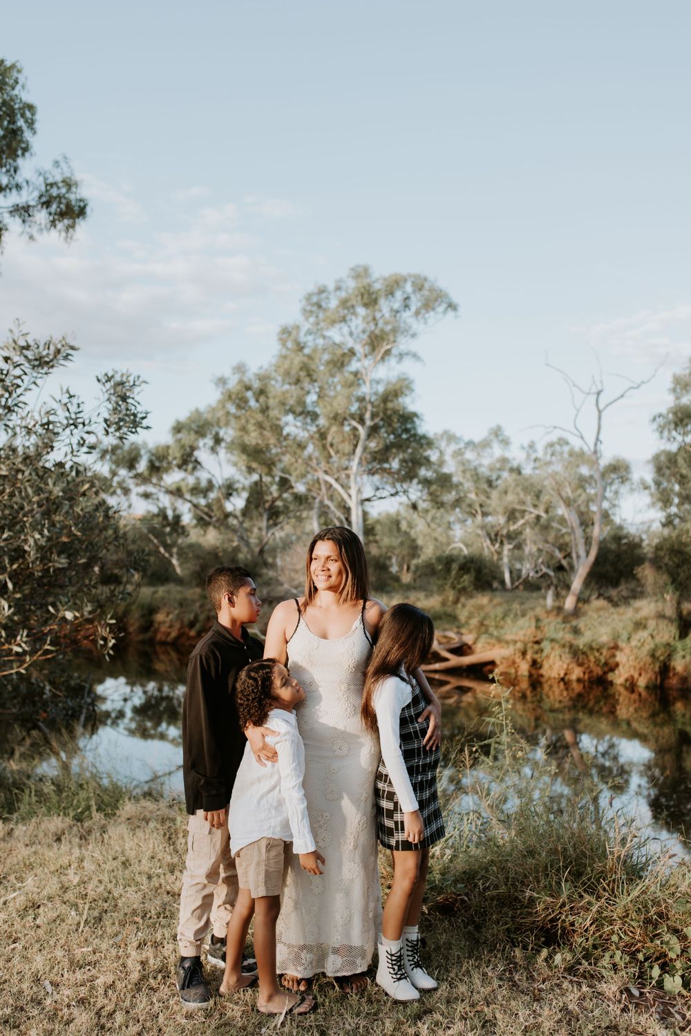 mother admires the sunset as children look out into the distance in Mount Isa