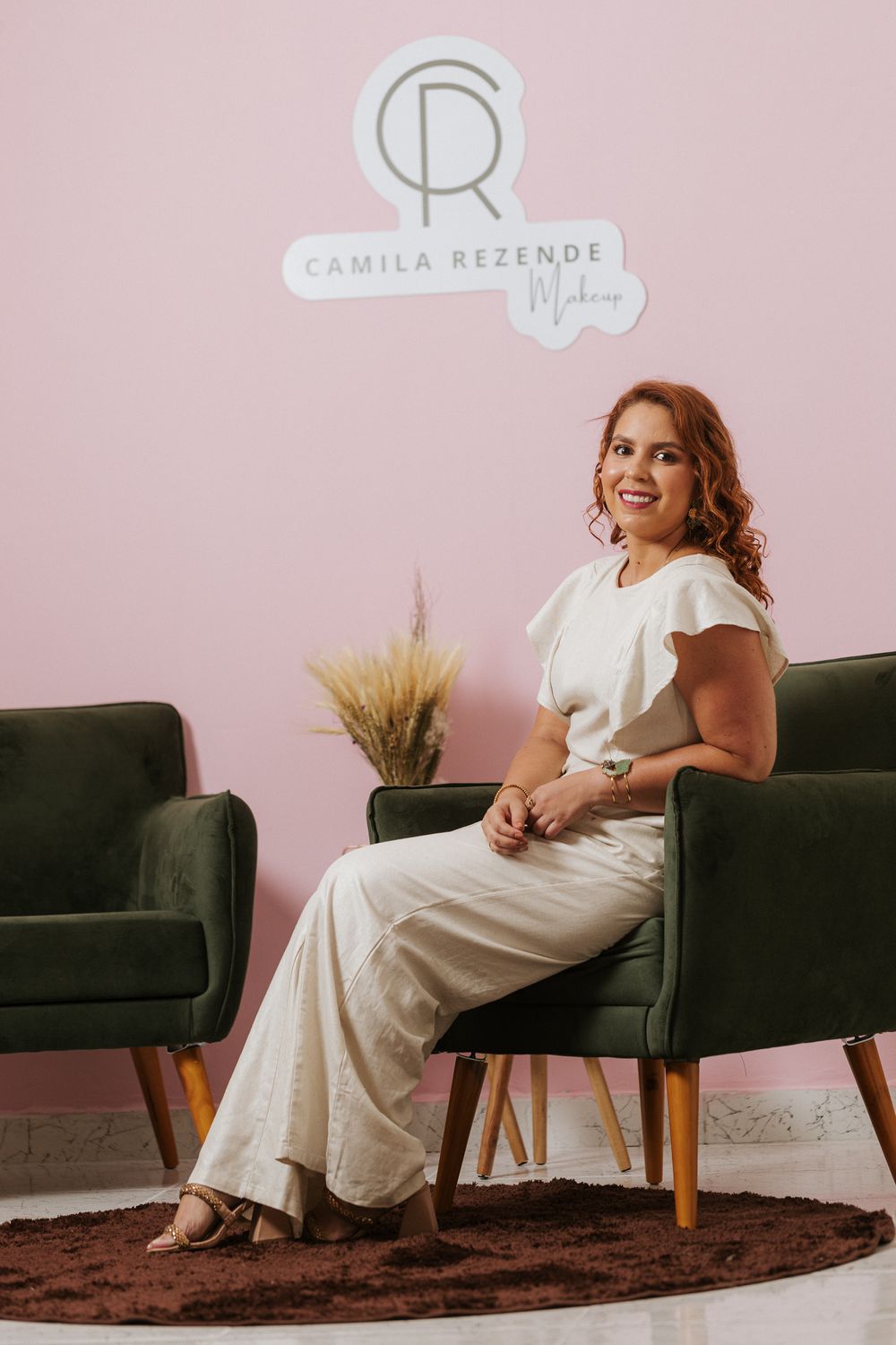 Lifestyle portrait on black couch with pink wall background.