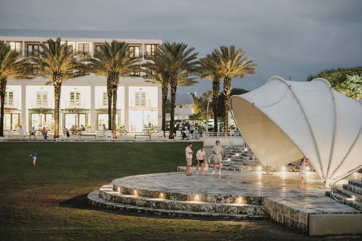 A panoramic view of a beachfront venue with palm trees and white tents.
