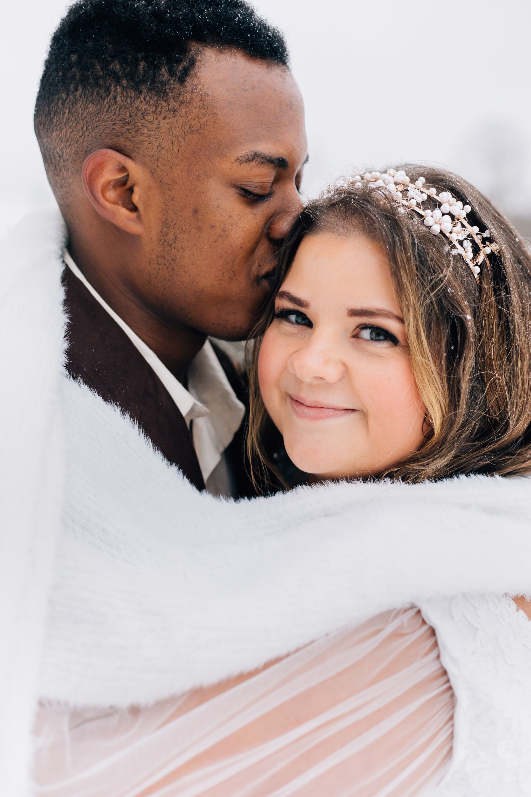 A romantic winter wedding portrait with bride wearing delicate veil and crystal hairpiece.