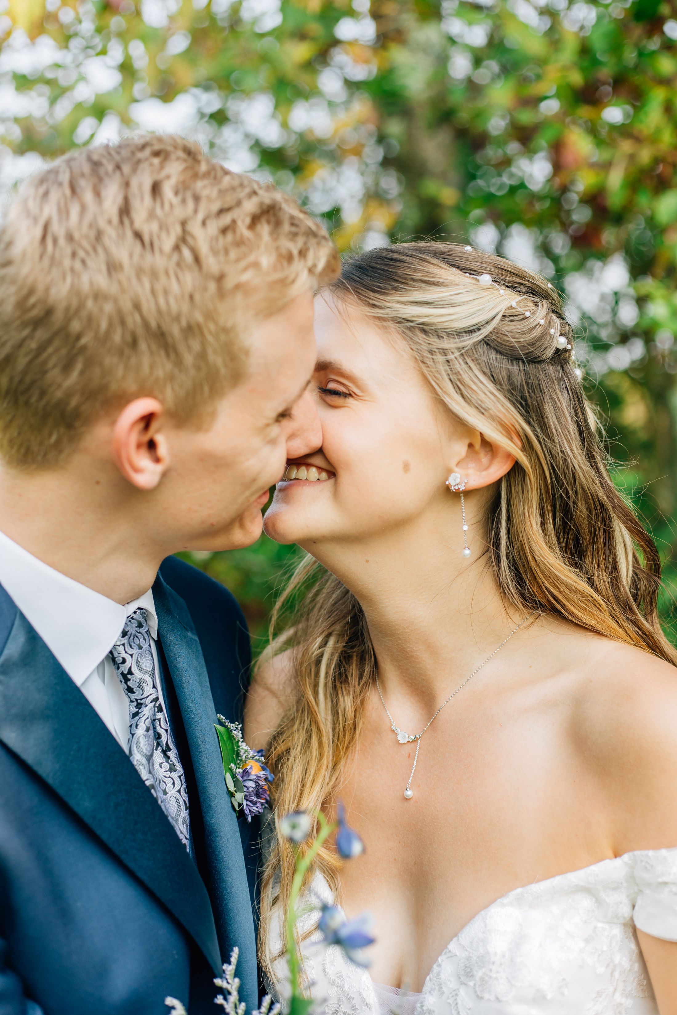 Romantic wedding couple sharing an intimate moment in an outdoor garden setting.