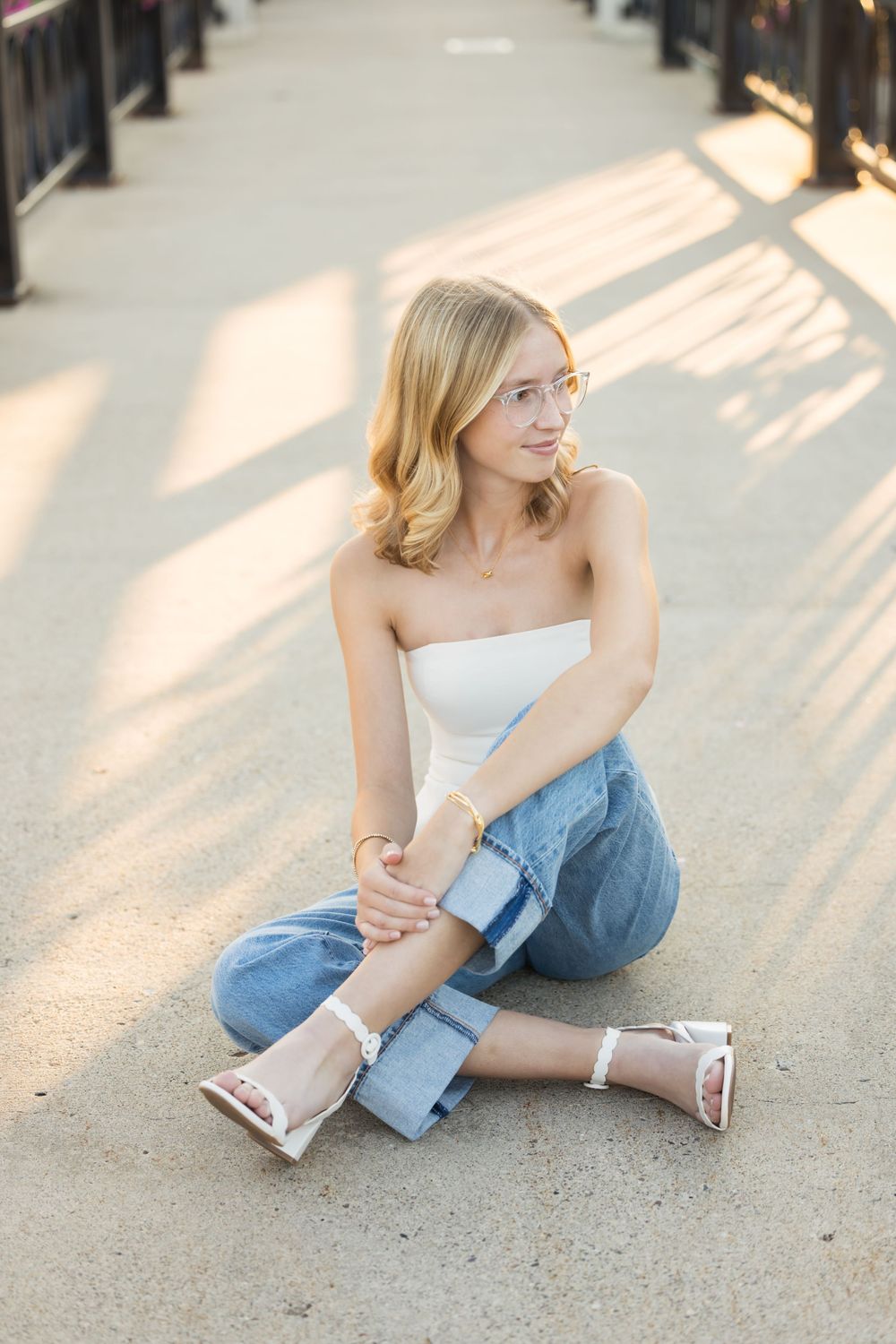 Casual outdoor portrait session on concrete with dramatic shadows and sunlight.