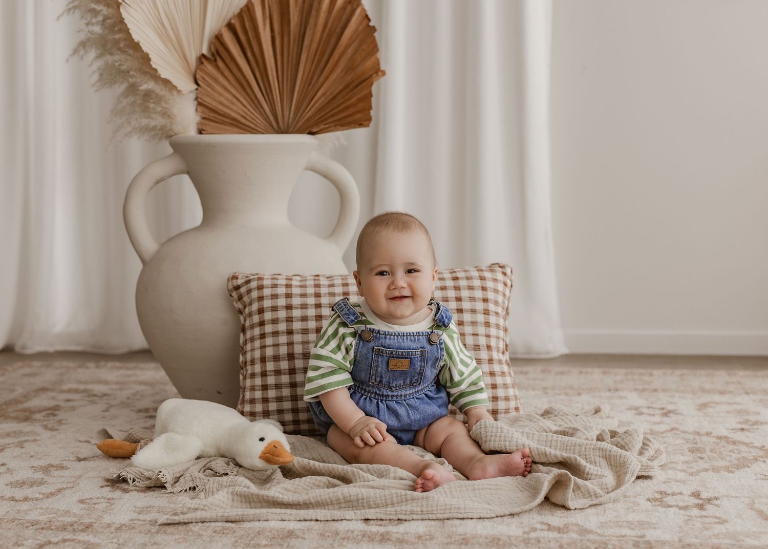 Matching outfits and sweet smiles on white chair with boho decor.
Photographed in a studio located in Papamoa, Tauranga