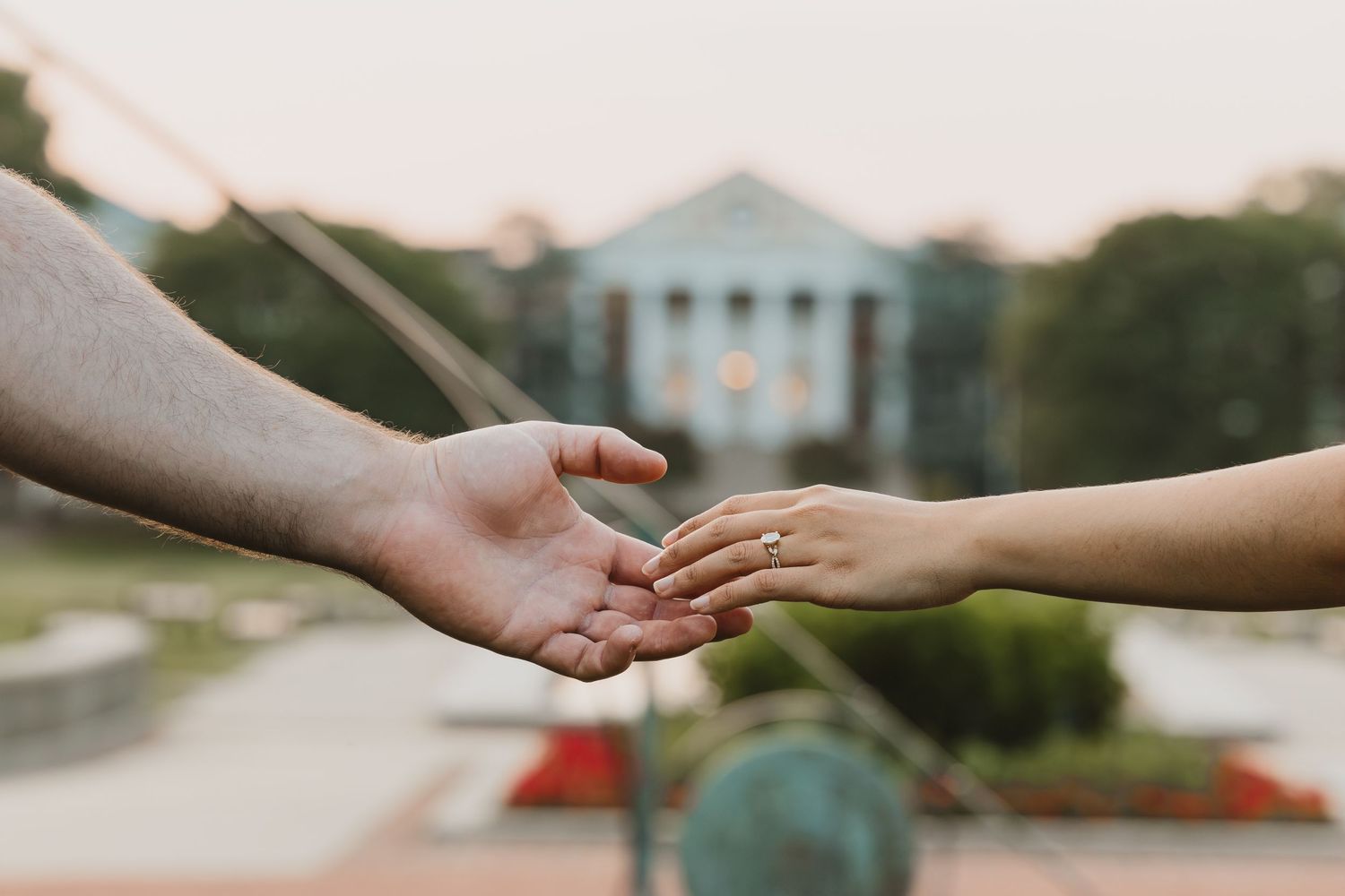 Close-up of two hands reaching towards each other at University of Maryland campus.