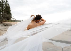 A flowing white veil catches the wind across a beach landscape in a series of romantic wedding photographs.